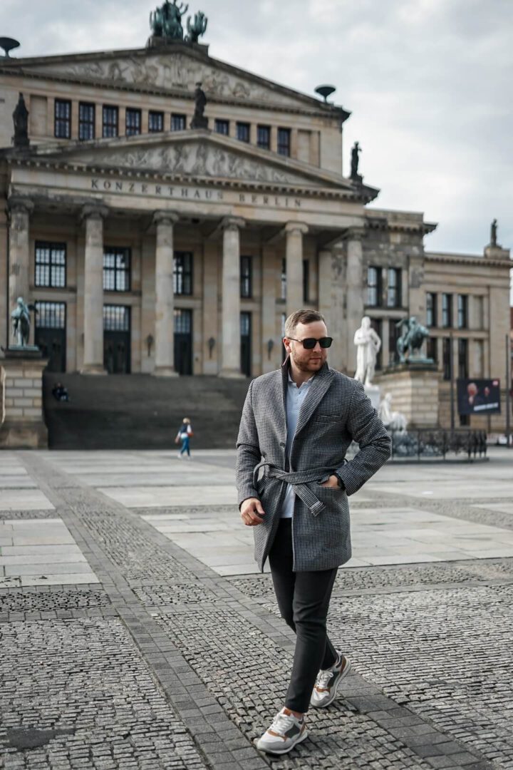 Der Mantel mit Gürtel mit einem lockeren Outfit beim Reisen, hier in Berlin am Gendarmenmarkt